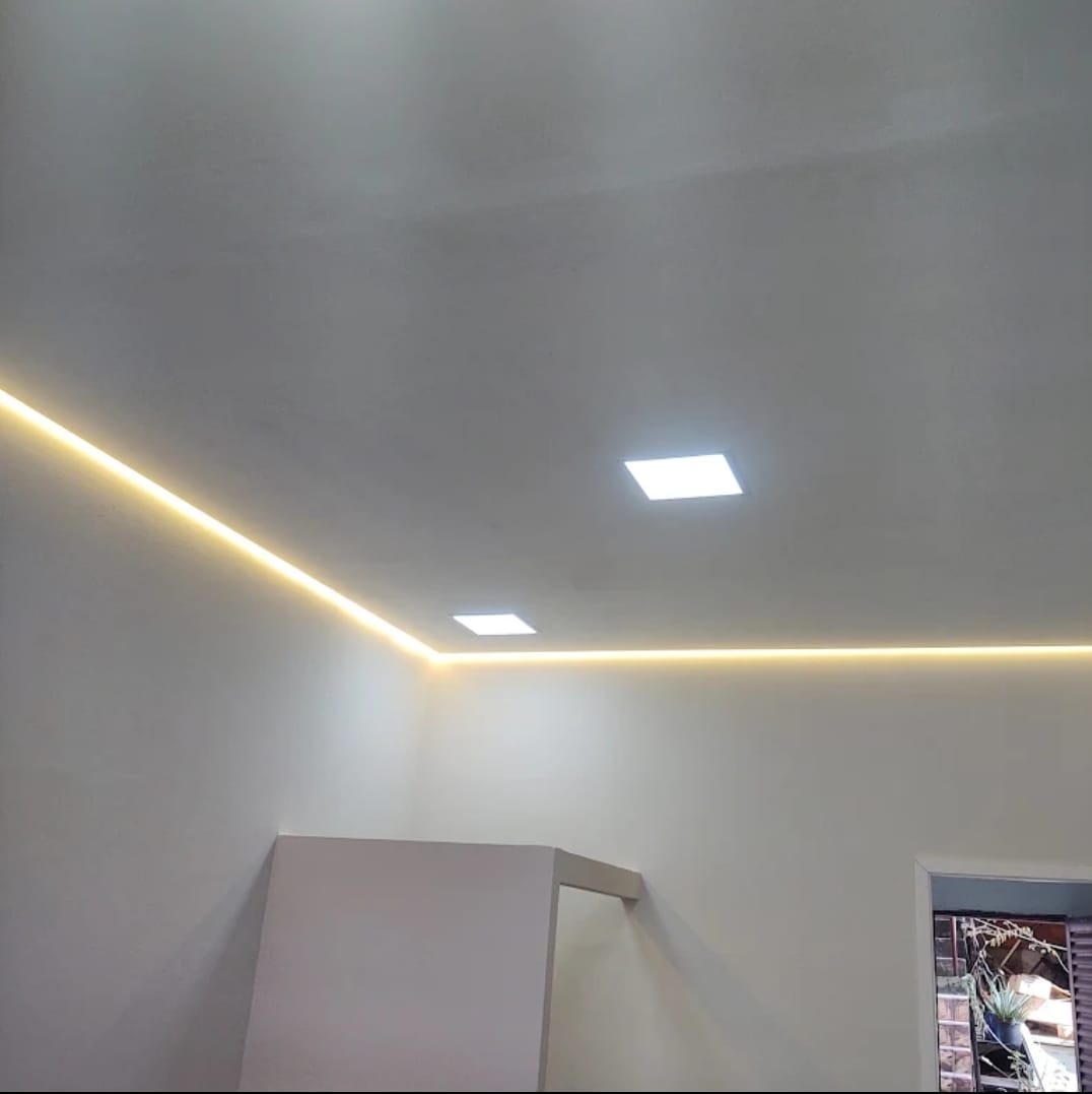 Teto branco de ambiente interno com iluminação embutida em LED (fita de luz amarelada perimetral e plafons…